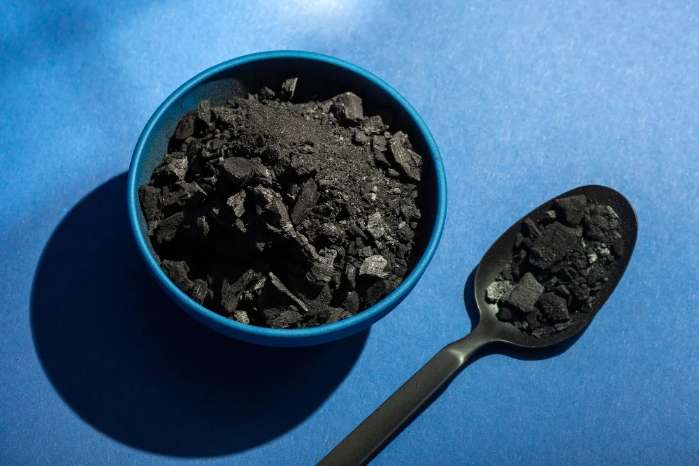 Shilajit for men - dark shilajit resin in a bowl with a spoon